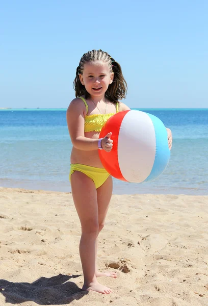 Gelukkig meisje met bal op strand — Stockfoto