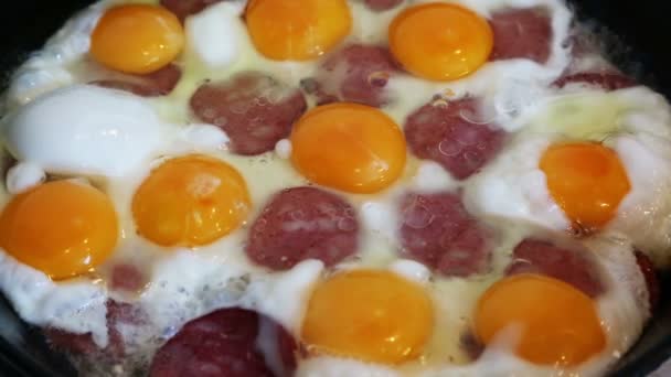 Grands œufs et saucisses frits dans une poêle — Video