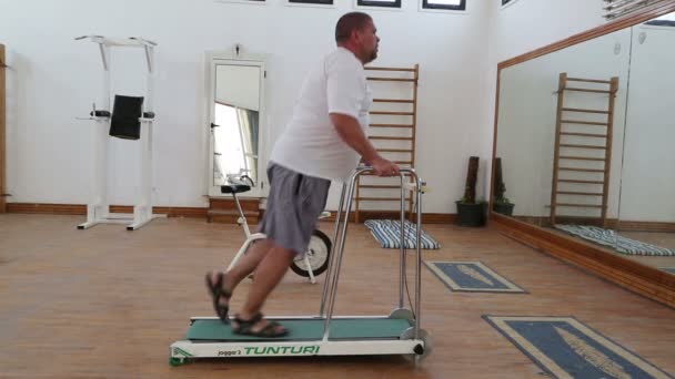 Uomo in sovrappeso che corre sul tapis roulant trainer — Video Stock