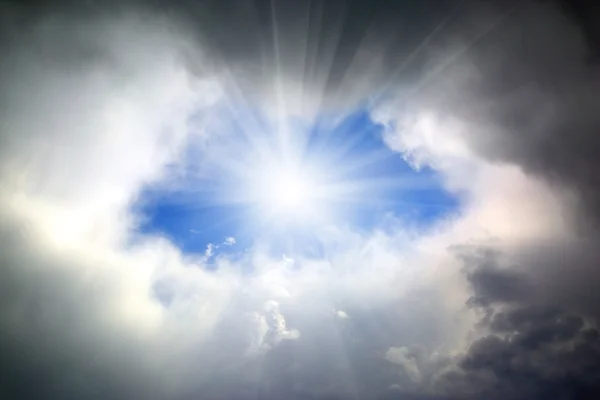 Sun shining through hole in clouds — Stock Photo, Image