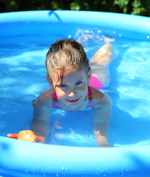 Mädchen badet in aufblasbarem Pool — Stockfoto