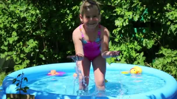 Chica en piscina inflable en jardín de verano — Vídeo de stock