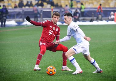KYIV, UKRAINE - NOVEMBER 23, 2021: Bayern Münih 'ten (L) Thomas Muller, NSC Olimpiyskyi Stadyumu' nda oynanan UEFA Şampiyonlar Ligi maçında Dinamo Kyiv takımından Mykola Shaparenko ile top için mücadele ediyor.
