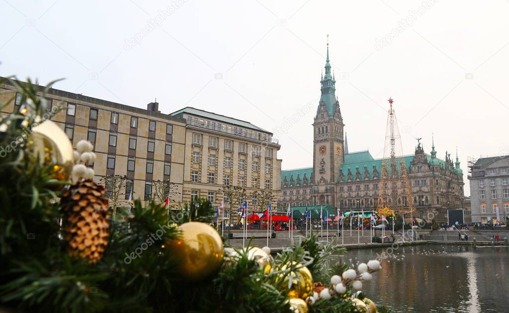 Winter view of Binnenalster lake and Christmas market at Town Hall square near Hamburg Town Hall (Hamburg Rathaus), Germany. Christmas decorations on a foreground