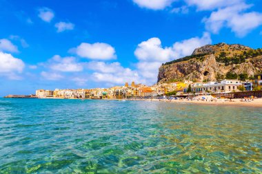 Cefalu sahili manzaralı, Cefalu kasabası, Sicilya, İtalya. Cefalu 'nun temiz, altın kumu olan uzun ve güzel bir plajı var. Arka planda La Rocca di Cefalu Dağı