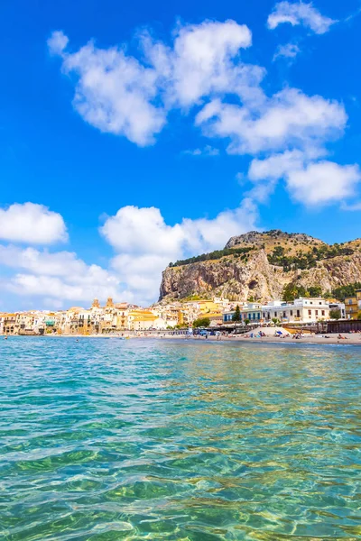 Cefalu sahilinde, Sicilya, İtalya 'nın Cefalu kasabasında, Akdeniz' in masmavi suları. Sicilya 'nın en iyi plajlarından biri. Arka planda La Rocca di Cefalu Dağı
