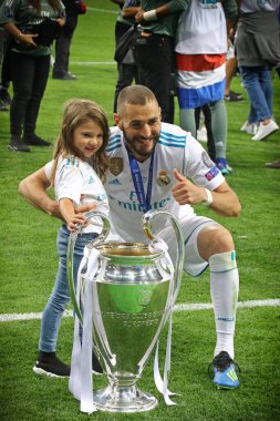 KYIV, UKRAINE - 26 Mayıs 2018: Real Madrid 'den Karim Benzema ve kızı Liverpool Şampiyonlar Ligi 2018 final maçının ardından Şampiyonlar Ligi Kupası (Kupa) ile poz verdiler.