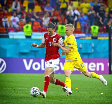 BÜKREŞ, ROMANIA - 21 Haziran 2021: Avusturyalı Florian Grillitsch (L) Ukraynalı Oleksandr Zinchenko ile UEFA EURO 2020 maçında Milli Arena Bükreş Stadyumu 'nda top için mücadele ediyor.