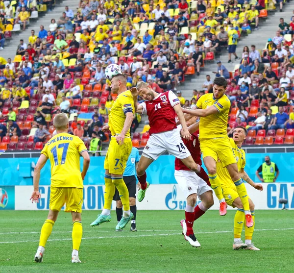 BÜKREŞ, ROMANIA - 21 Haziran 2021: Ukraynalı (Sarı) ve Avusturyalı oyuncular, UEFA EURO 2020 'de Bükreş Ulusal Arena Stadyumu' nda oynadıkları maçta bir top için mücadele ediyorlar. Avusturya 1-0 kazandı