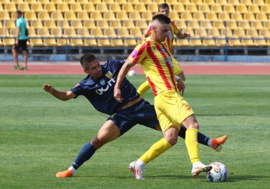 Uzhhorod, Ukrayna - 29 Ağustos 2022: Metalist Harkiv 'li Serhii Panasenko, VBET Ukrayna Premier Ligi maçı sırasında Inhulet' li Taras Sakiv ile Avanhard Stadyumu 'nda top için mücadele ediyor.