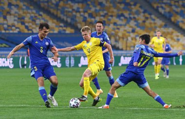KYIV, UKRAINE - 31 Mart 2021: Ukraynalı Oleksandr Zinchenko, 2022 FIFA Dünya Kupası eleme turu sırasında Nuraly Alip ve Timur Dosmagambetov ile bir top için mücadele ediyor.