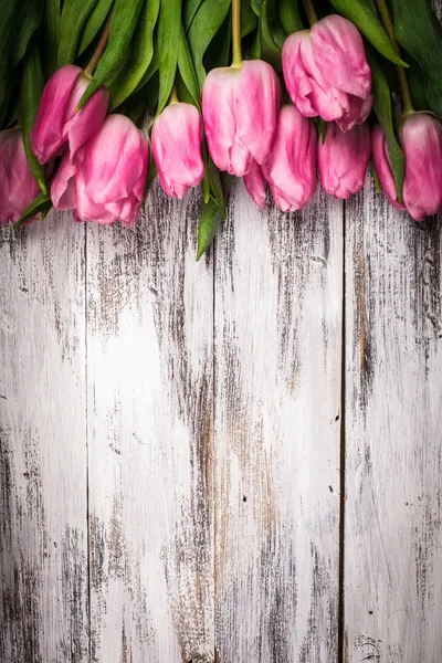 Розовые тюльпаны над деревянным столом — стоковое фото