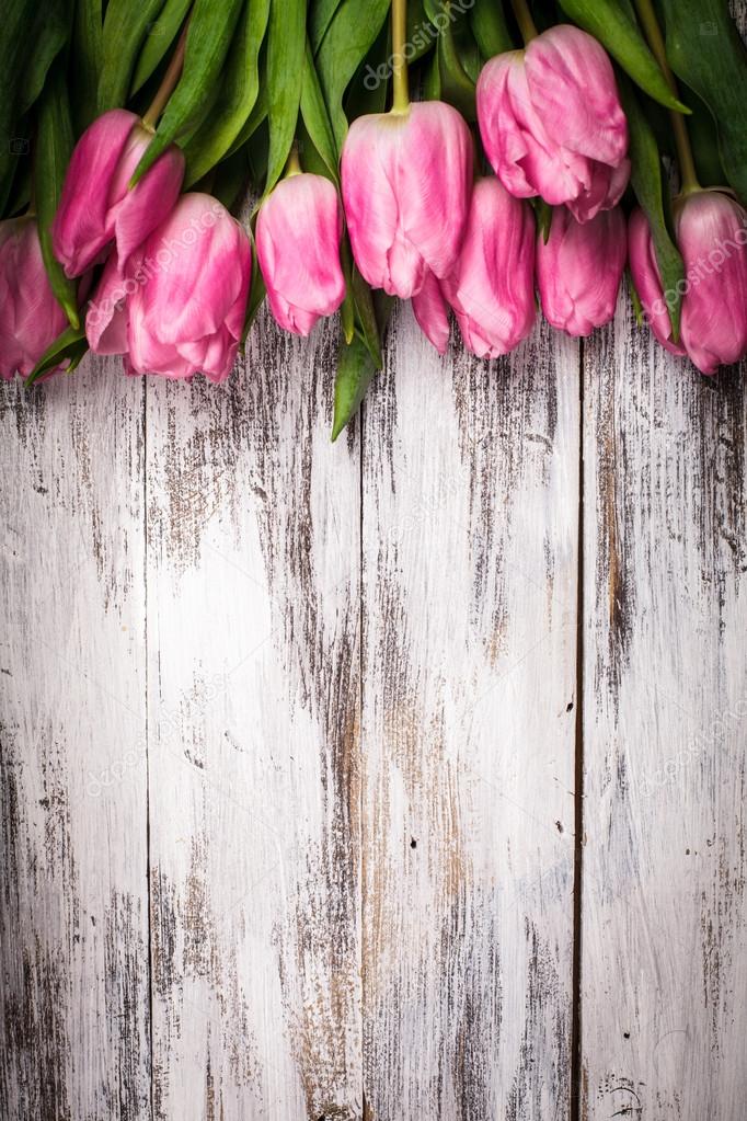 Pink tulips over wooden table