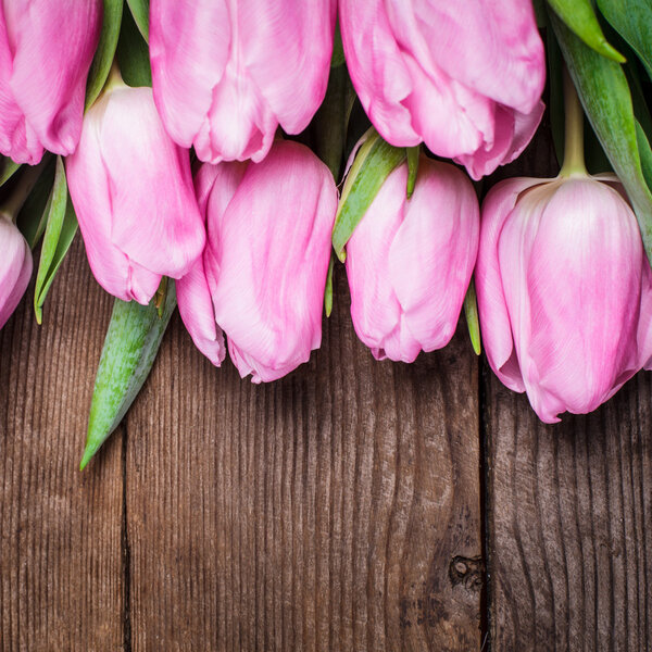 Pink tulips over wooden table