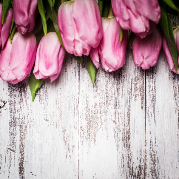 Pink tulips over wooden table — Stock Photo, Image