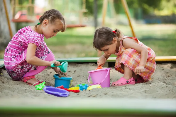 2 人の女の子は、サンド ボックス内で再生します。 — ストック写真