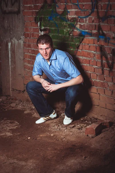 Man leaning on a brick wal — Stock Photo, Image