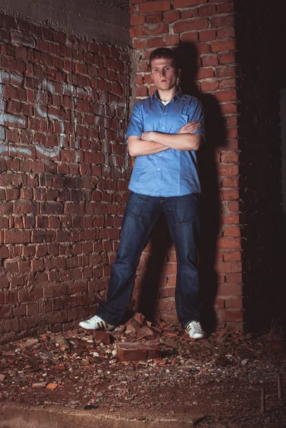 Man leaning on a brick wal — Stock Photo, Image