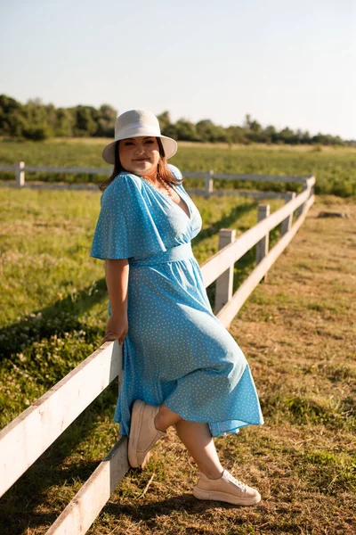 Mujer cándida en el sombrero en las tierras de cultivo disfrutar del verano — Foto de Stock