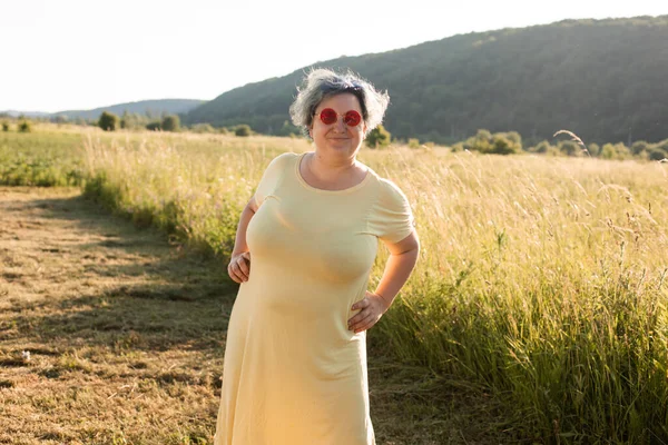 Die fröhliche junge Frau mit Sonnenbrille genießt die Natur — Stockfoto