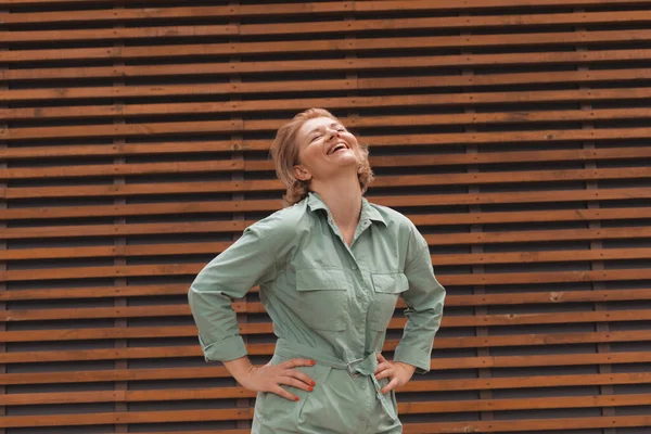 Muchacha atractiva sonriendo, de pie sobre fondo de pared de madera — Foto de Stock