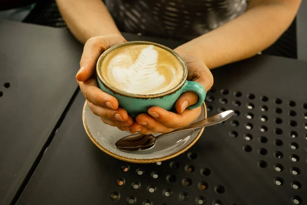 Vrouw met beker met cappuccino in handen — Stockfoto