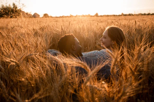 Abrazar pareja reunión puesta de sol en un campo de trigo — Foto de Stock