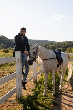 Adam çiftlikte bir atla dinleniyor.