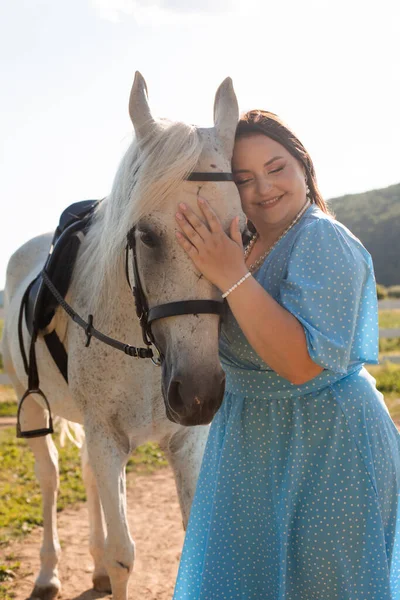 卷曲头发的女人拥抱着她的马 — 图库照片