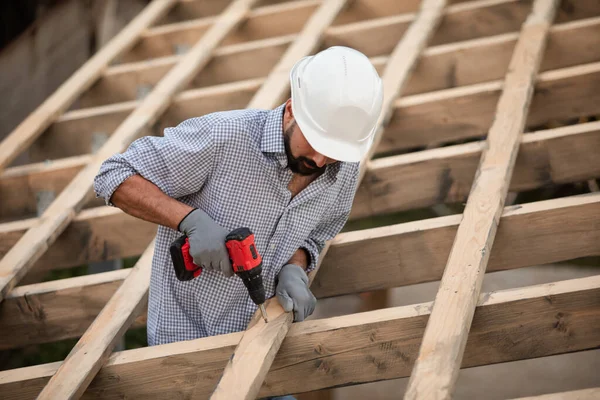 De jonge bouwer werkt op een onafgewerkt dak — Stockfoto