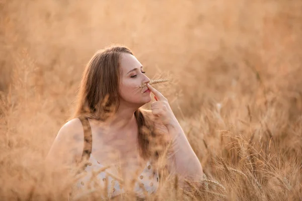 Charming woman posing in field playing with rye ear — Stock Photo, Image