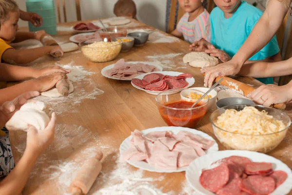 Dos tutoras enseñan a los niños a hacer pizza —  Fotos de Stock