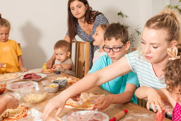 Pedagogové spolu s předškoláky dělají pizzu — Stock fotografie