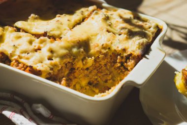 Çobanlar, masada beyaz yemek tabağında turta yiyorlar.