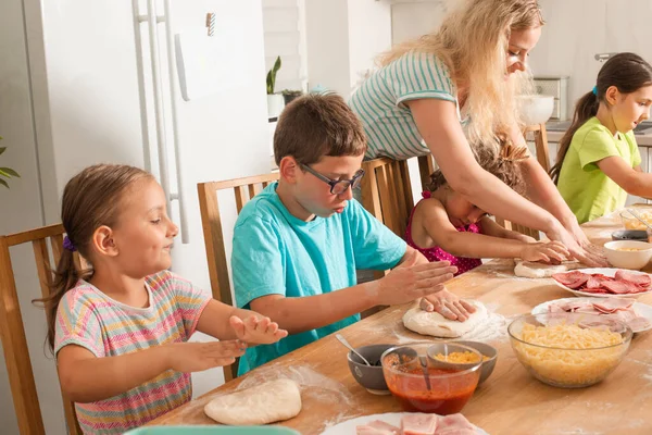 El maestro está aprendiendo a los niños a cocinar pizza —  Fotos de Stock