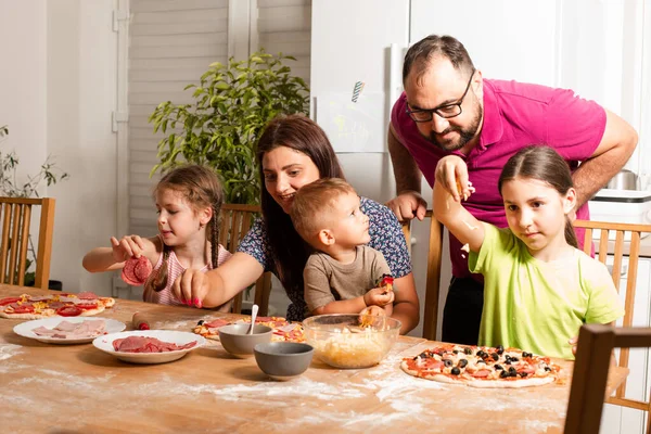 The young parents are cooking with their children — Stock Photo, Image