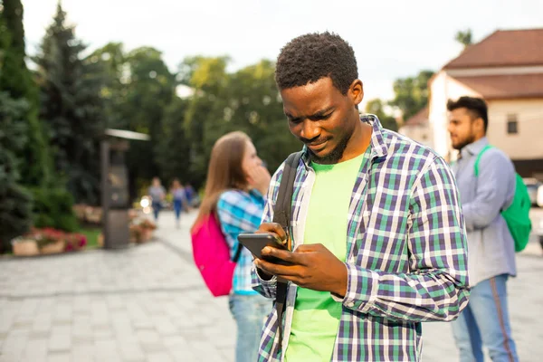 El joven estudiante utiliza la navegación en un smartphone — Foto de Stock