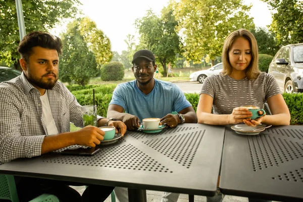 Alegres jóvenes amigos divirtiéndose mientras hablan en un café — Foto de Stock