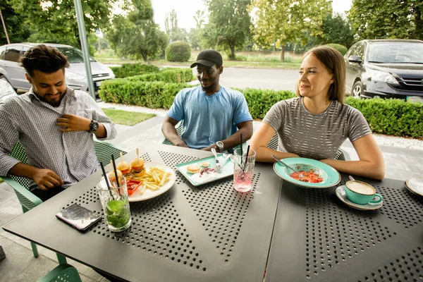 Joyeux jeunes amis s'amuser tout en parlant dans un café — Photo