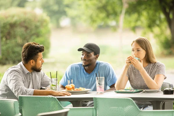 Alegres jóvenes amigos divirtiéndose mientras hablan en un café — Foto de Stock