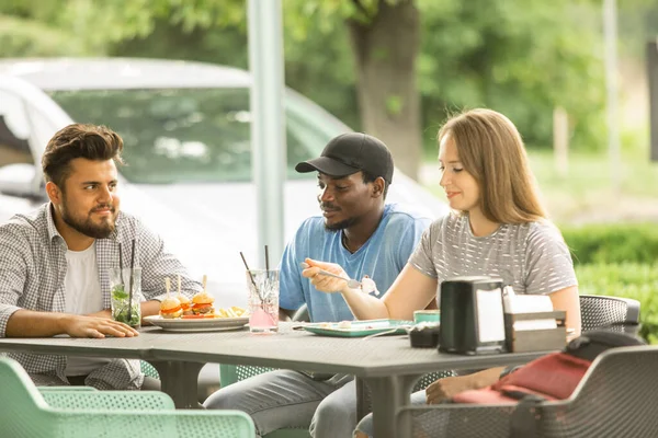 Grupo de jóvenes reunidos en una cafetería — Foto de Stock