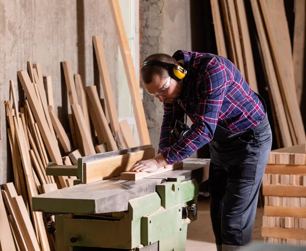 Madeira de corte de carpinteiro experiente com serra elétrica — Fotografia de Stock