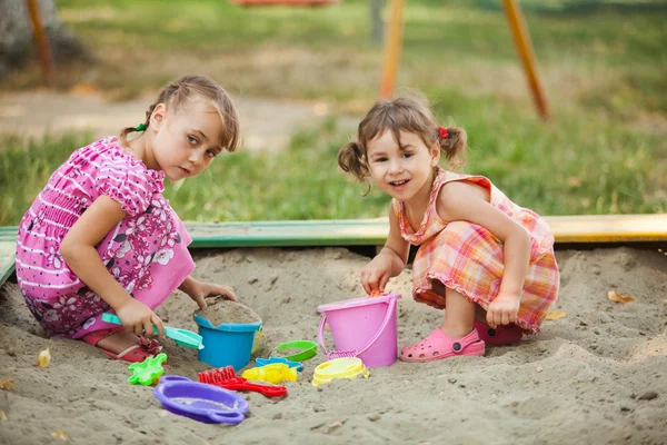 Two girls play in the sandbox — Stock Photo, Image