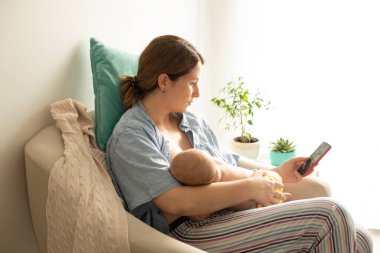 Rahat ve huzurlu bir şekilde evdeki rahat koltukta emziriliyor.