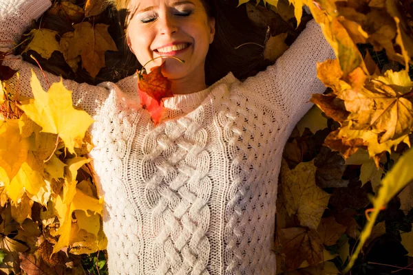 Femme posée dans des feuilles d'érable dans le parc. — Photo