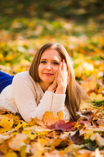 Femme posée dans des feuilles d'érable dans le parc. — Photo