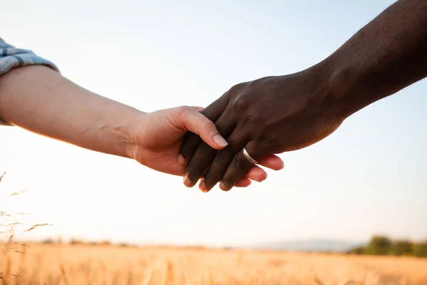 Relazione multirazziale e concetto di amicizia. Due mani che tengono insieme. — Foto Stock