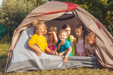 Çocuklar yaz kampında doğada dinleniyorlar.