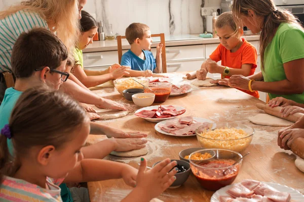 교육자들 과 취학전 아동들 이 피자를 만드는 모습 — 스톡 사진