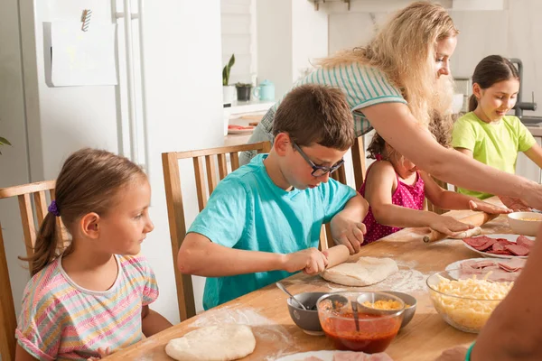 O professor está aprendendo as crianças a cozinhar pizza — Fotografia de Stock